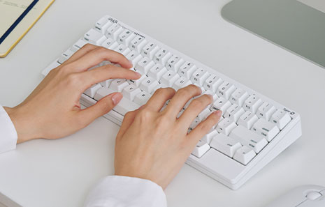  Personne tapant sur un HHKB HYBRID Type S Snow clavier imprimé